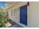 Bright blue front door accented by fresh white trim and updated lighting fixtures at 7704 Tanglewood Ln, Tampa, FL 33615