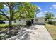 Quaint single-story home with a shade tree and freshly painted white brick at 7704 Tanglewood Ln, Tampa, FL 33615