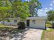 Charming home featuring a well-manicured front lawn and a brick facade at 7704 Tanglewood Ln, Tampa, FL 33615