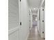 Hallway with plank floors, neutral paint, and multiple access doors at 7704 Tanglewood Ln, Tampa, FL 33615