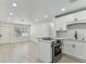 Eat-in kitchen boasts white cabinets, stainless steel appliances and light wood floors at 7704 Tanglewood Ln, Tampa, FL 33615