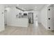 Modern eat-in kitchen with white cabinets, stainless steel appliances and light wood floors at 7704 Tanglewood Ln, Tampa, FL 33615