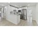 Eat-in kitchen boasts white cabinets, stainless steel appliances and light wood floors at 7704 Tanglewood Ln, Tampa, FL 33615