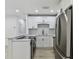 Modern kitchen features stainless appliances, white cabinets, and light wood floors at 7704 Tanglewood Ln, Tampa, FL 33615