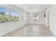 Sunlit living room featuring three large windows and a white entry door at 7704 Tanglewood Ln, Tampa, FL 33615