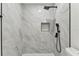 Modern shower with marble tile, built-in niche, and sleek black rainfall shower head at 7704 Tanglewood Ln, Tampa, FL 33615