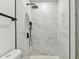 Modern shower with marble tile and sleek black rainfall shower head at 7704 Tanglewood Ln, Tampa, FL 33615