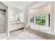Bright bathroom with a large tub, dual sinks, a separate shower and views of the outdoor scenery at 7803 Mathern Ct, Lakewood Ranch, FL 34202