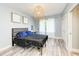 Bedroom features modern lighting fixture, neutral walls, and wood-look flooring at 7803 Mathern Ct, Lakewood Ranch, FL 34202