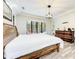 Bedroom boasts gray washed wood flooring, a wooden bed frame and dark trimmed window views at 7803 Mathern Ct, Lakewood Ranch, FL 34202