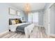 Cozy bedroom with light blue walls, wood-style flooring, and stylish woven pendant light at 7803 Mathern Ct, Lakewood Ranch, FL 34202