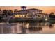 A waterfront luxury home at twilight with a large fountain, patio and balconies overlooking a tranquil pond at 7803 Mathern Ct, Lakewood Ranch, FL 34202