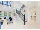 Spacious foyer with staircase, decorative railing, and large windows showcasing natural light at 7803 Mathern Ct, Lakewood Ranch, FL 34202