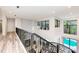 Hallway with decorative railing overlooking the pool area with large windows at 7803 Mathern Ct, Lakewood Ranch, FL 34202