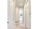 Hallway showing access to bathroom with white cabinets and gray washed wood flooring at 7803 Mathern Ct, Lakewood Ranch, FL 34202