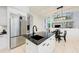Kitchen island with black countertop and stainless steel refrigerator, adjacent to dining area at 7803 Mathern Ct, Lakewood Ranch, FL 34202