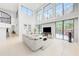 Bright living room with high ceilings, sliding glass doors, and comfortable neutral-toned furnishings at 7803 Mathern Ct, Lakewood Ranch, FL 34202