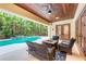 Charming outdoor living space with a cozy fire table, comfortable seating, and a view of the pool at 7803 Mathern Ct, Lakewood Ranch, FL 34202