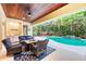 Inviting outdoor living area with a Tiki bar, comfortable seating, and a view of the pool at 7803 Mathern Ct, Lakewood Ranch, FL 34202