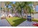 Beautiful backyard with tropical landscaping, white fence, and an outdoor grill at 827 Placido Ne Way, St Petersburg, FL 33704