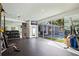 Bright home gym with mirrored walls, TV, and access to the outdoor pool area at 827 Placido Ne Way, St Petersburg, FL 33704