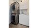 A convenient laundry area with a stacked washer and dryer unit and built-in sink with cabinet at 827 Placido Ne Way, St Petersburg, FL 33704
