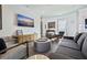 Living room with modern gray furniture, TV, and decor that complements the tile flooring at 827 Placido Ne Way, St Petersburg, FL 33704