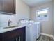 Functional laundry room with washer, dryer, sink, and storage cabinet space at 8289 136Th St, Seminole, FL 33776