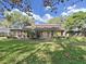 Spacious backyard featuring a well-maintained lawn, mature trees, and a patio area at 852 Village Way, Palm Harbor, FL 34683