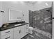 Modern bathroom with black and white marble-look tile, stylish vanity, and a glass walk-in shower at 852 Village Way, Palm Harbor, FL 34683
