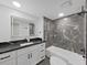 Updated bathroom featuring a stylish vanity with a black countertop and a tub shower combo at 852 Village Way, Palm Harbor, FL 34683