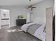Neutral bedroom with gray wood floors, a ceiling fan, and en-suite bathroom access at 852 Village Way, Palm Harbor, FL 34683