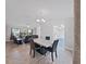 Open concept dining room shows living room with leather furniture in the background at 852 Village Way, Palm Harbor, FL 34683