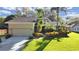 Charming two-story home features a well-manicured lawn, colorful landscaping, and an attached two-car garage at 852 Village Way, Palm Harbor, FL 34683