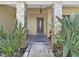 Inviting front porch with stone pillars and decorative plants at 852 Village Way, Palm Harbor, FL 34683