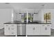 Bright kitchen island boasts modern appliances, sleek black countertops, and ample storage space at 852 Village Way, Palm Harbor, FL 34683