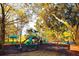 Community playground with slides and play equipment, surrounded by shady trees and benches at 9481 Highland Oak Dr # 1101, Tampa, FL 33647