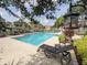 Community pool area featuring lounge chairs, landscaping, and inviting turquoise water at 9481 Highland Oak Dr # 1101, Tampa, FL 33647