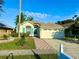 Inviting single-story home featuring a two-car garage, verdant lawn, and a walkway to the front door at 9614 Long Meadow Dr, Tampa, FL 33615