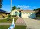 Charming one-story home featuring a manicured lawn, walkway, and attached garage at 9614 Long Meadow Dr, Tampa, FL 33615