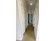 Hallway with bi-fold closet and light ceramic tile flooring, connecting to additional rooms at 9614 Long Meadow Dr, Tampa, FL 33615