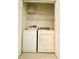 Bright laundry room features a full-size washer and dryer, plus wire shelving for extra storage space at 9614 Long Meadow Dr, Tampa, FL 33615