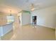 Open living space featuring tile flooring, neutral walls, a ceiling fan, and seamless flow to the kitchen at 9614 Long Meadow Dr, Tampa, FL 33615