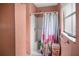 A small bathroom with a shower and tub combination with peach-colored walls at 100 94Th Ave, Treasure Island, FL 33706