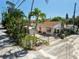 Charming house with a fenced yard, mature trees, and a shed on a sunny day at 100 94Th Ave, Treasure Island, FL 33706