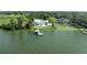 Waterfront property featuring a modern home with a pool, private dock, and stunning lake views from above at 11313 Knights Griffin Rd, Thonotosassa, FL 33592