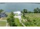 Expansive aerial view showcasing the modern waterfront home with a private dock and lush green surroundings at 11313 Knights Griffin Rd, Thonotosassa, FL 33592