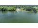 Waterfront property featuring a modern home with a pool, private dock, and stunning lake views from above at 11313 Knights Griffin Rd, Thonotosassa, FL 33592