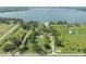 Expansive aerial view showcasing the modern waterfront home with a private dock and lush green surroundings at 11313 Knights Griffin Rd, Thonotosassa, FL 33592