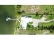 Aerial view showcasing the modern waterfront home with a private dock, putting green, and lush green surroundings at 11313 Knights Griffin Rd, Thonotosassa, FL 33592